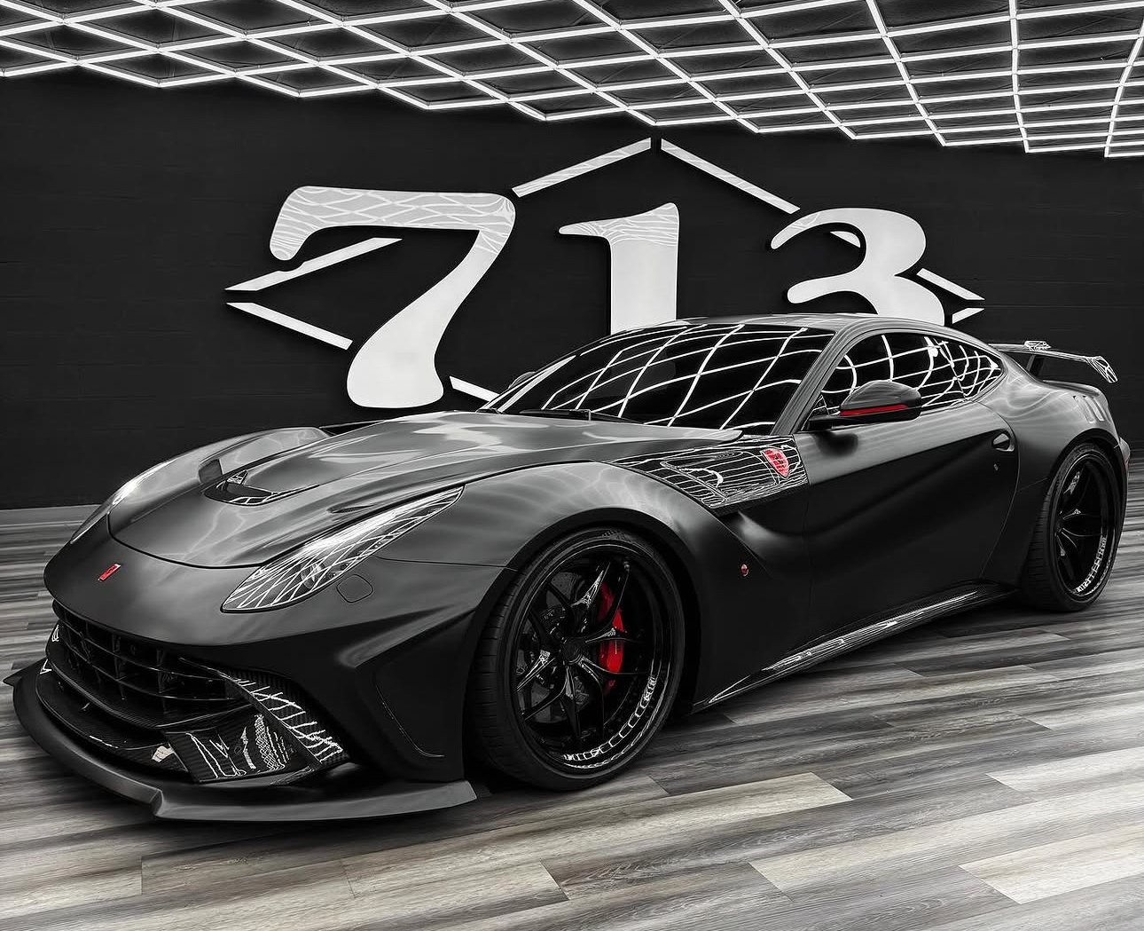 Matte black widebody Ferrari displayed inside 713 Motors